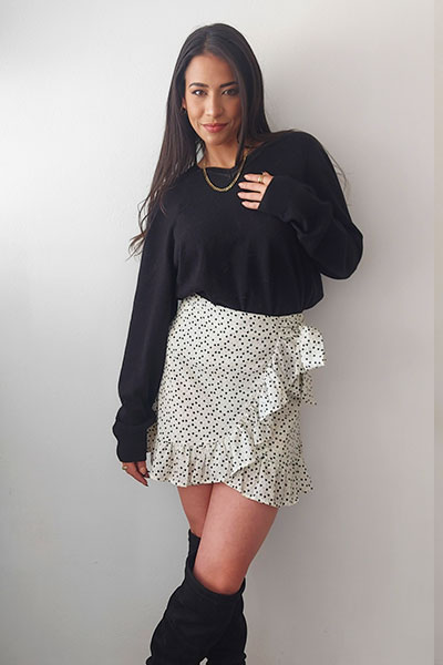 Autum outfit in nude colors with black sweater, white dot skirt and black boots.